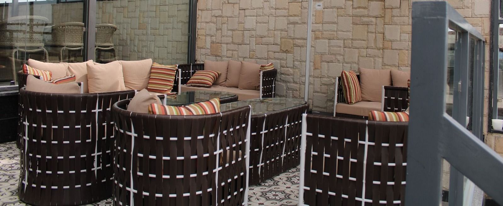 Back view of a rooftop lounge featuring stylish seating arrangements and a spacious patio area at BluSalzz Residence, Amritsar 